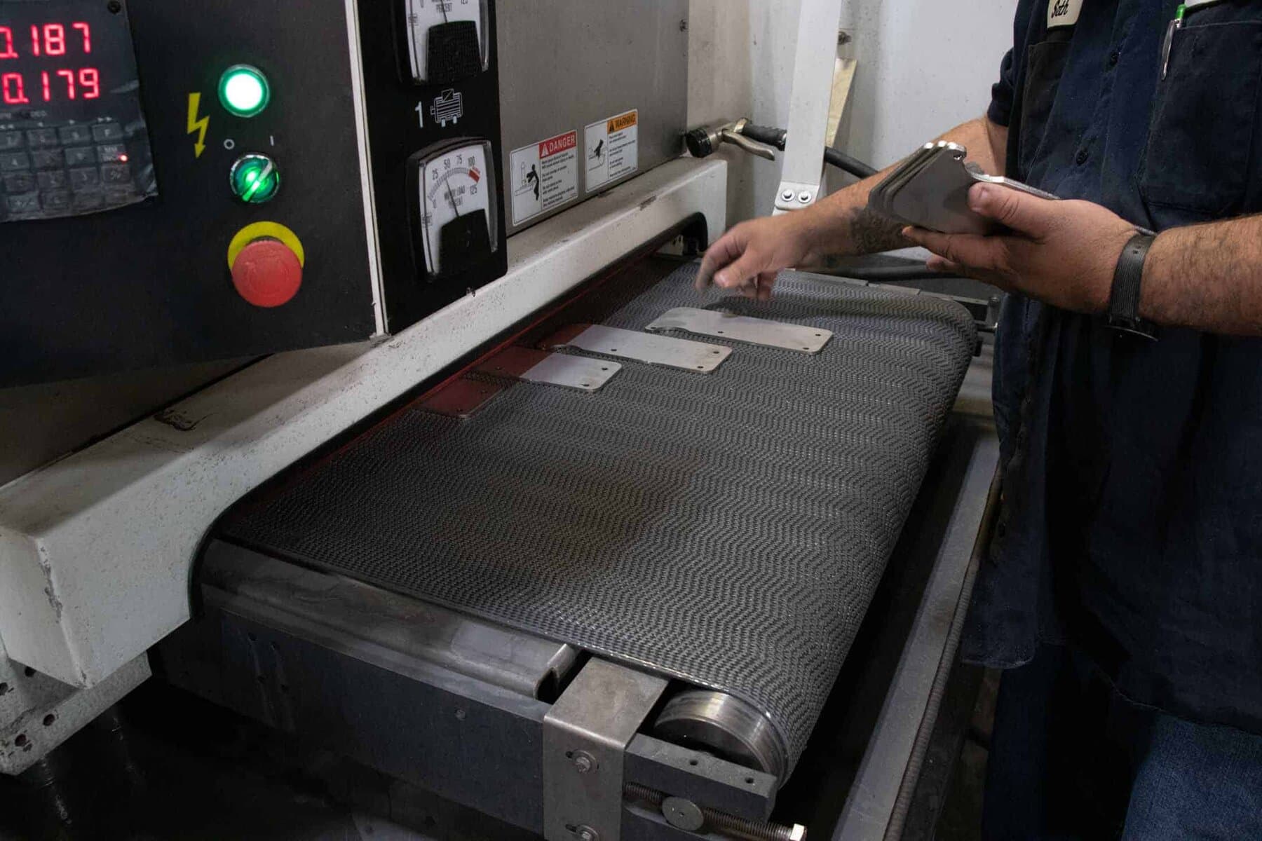 Sheet-metal parts running through a Timesaver deburring machine