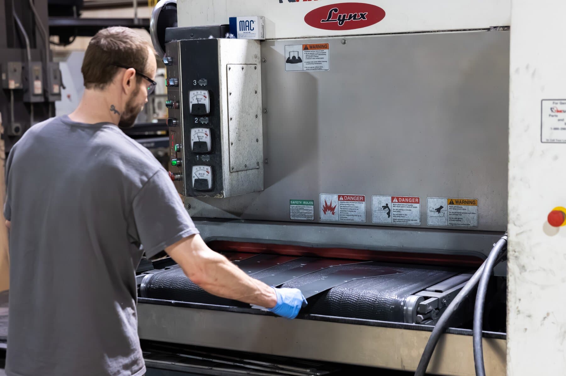 Operator finishing parts on a Timesaver grain-finish line