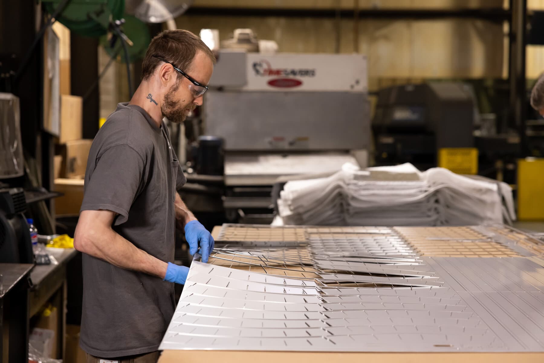 Technician denesting laser-cut parts from a sheet
