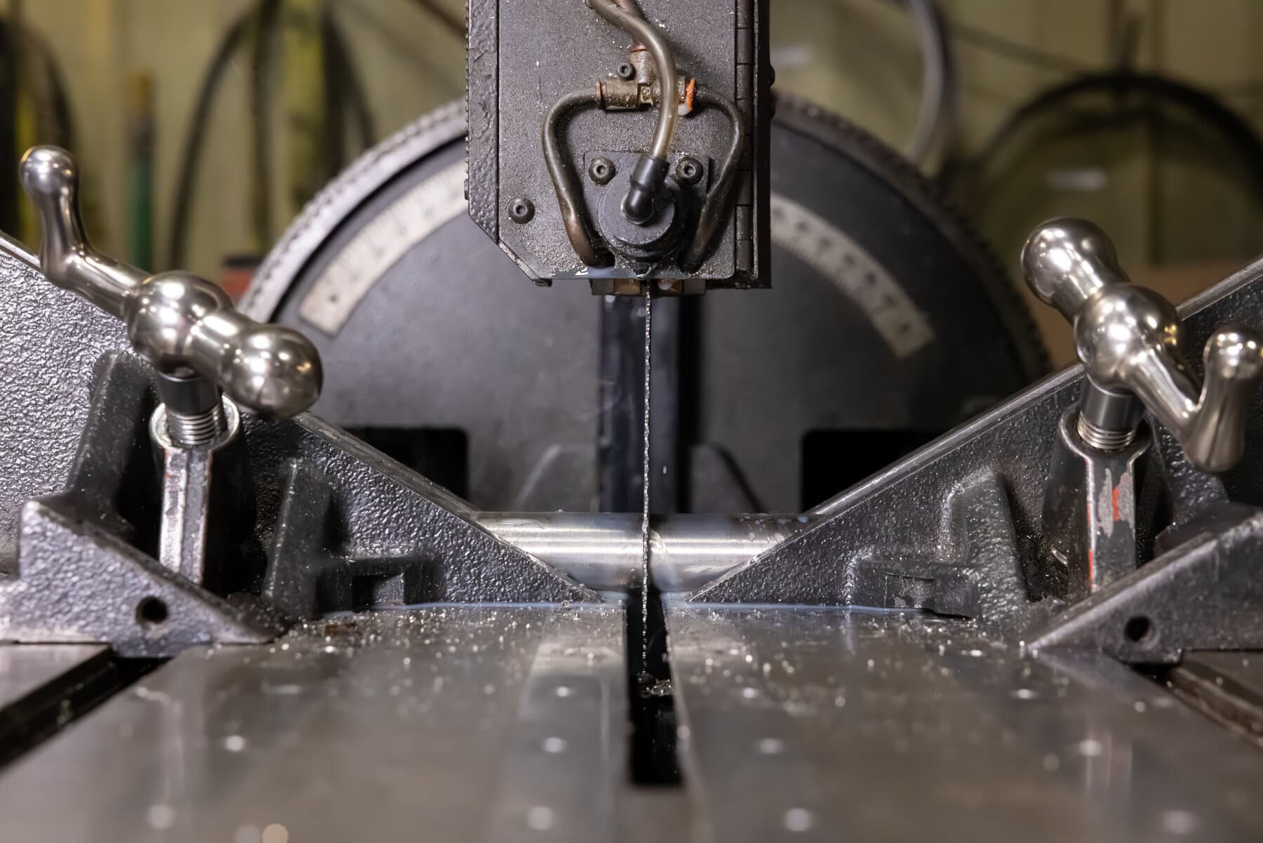 Band saw blade cutting a round steel tube