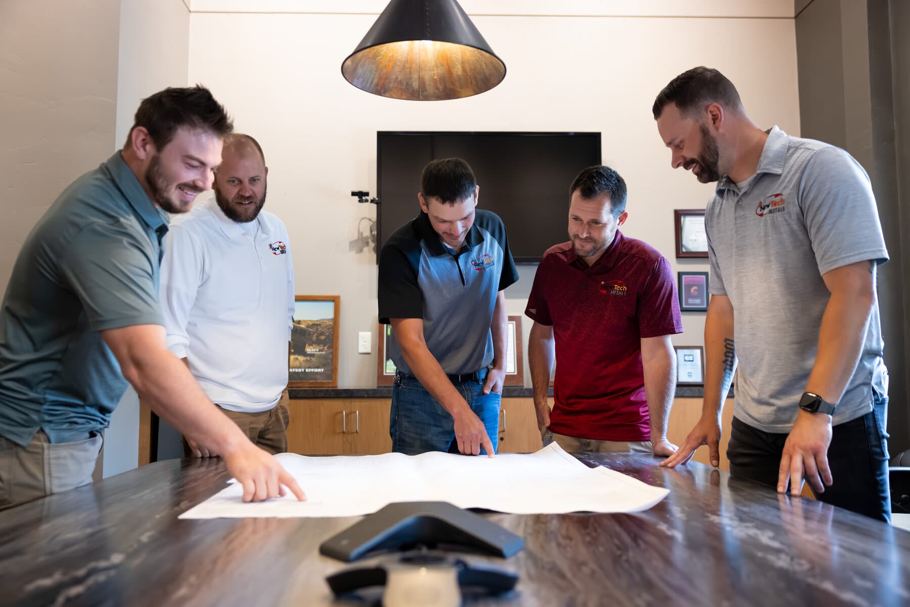 New Tech Metals engineering team reviewing drawings together in the conference room