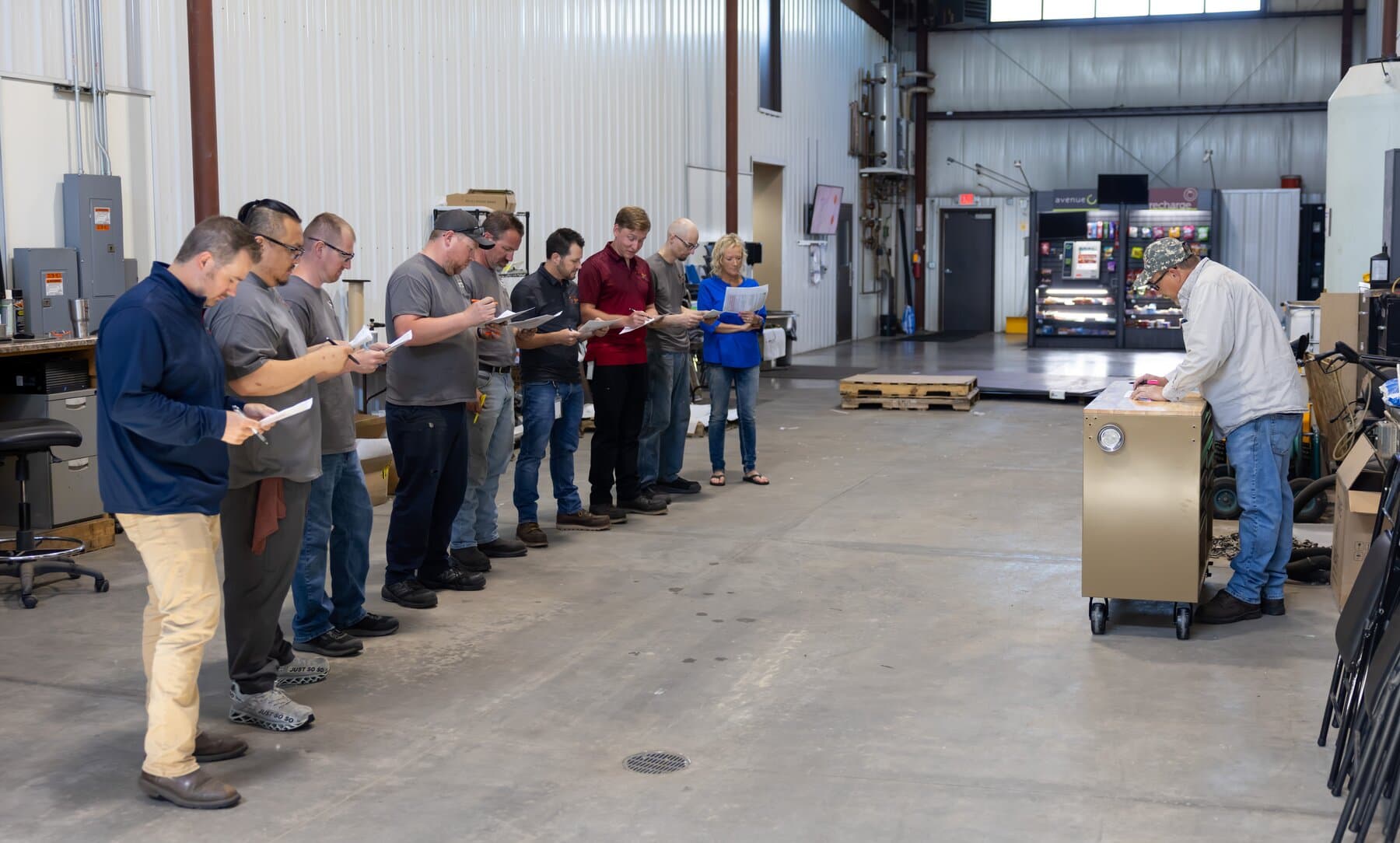 New Tech Metals team reviewing work orders at a shop-floor production meeting