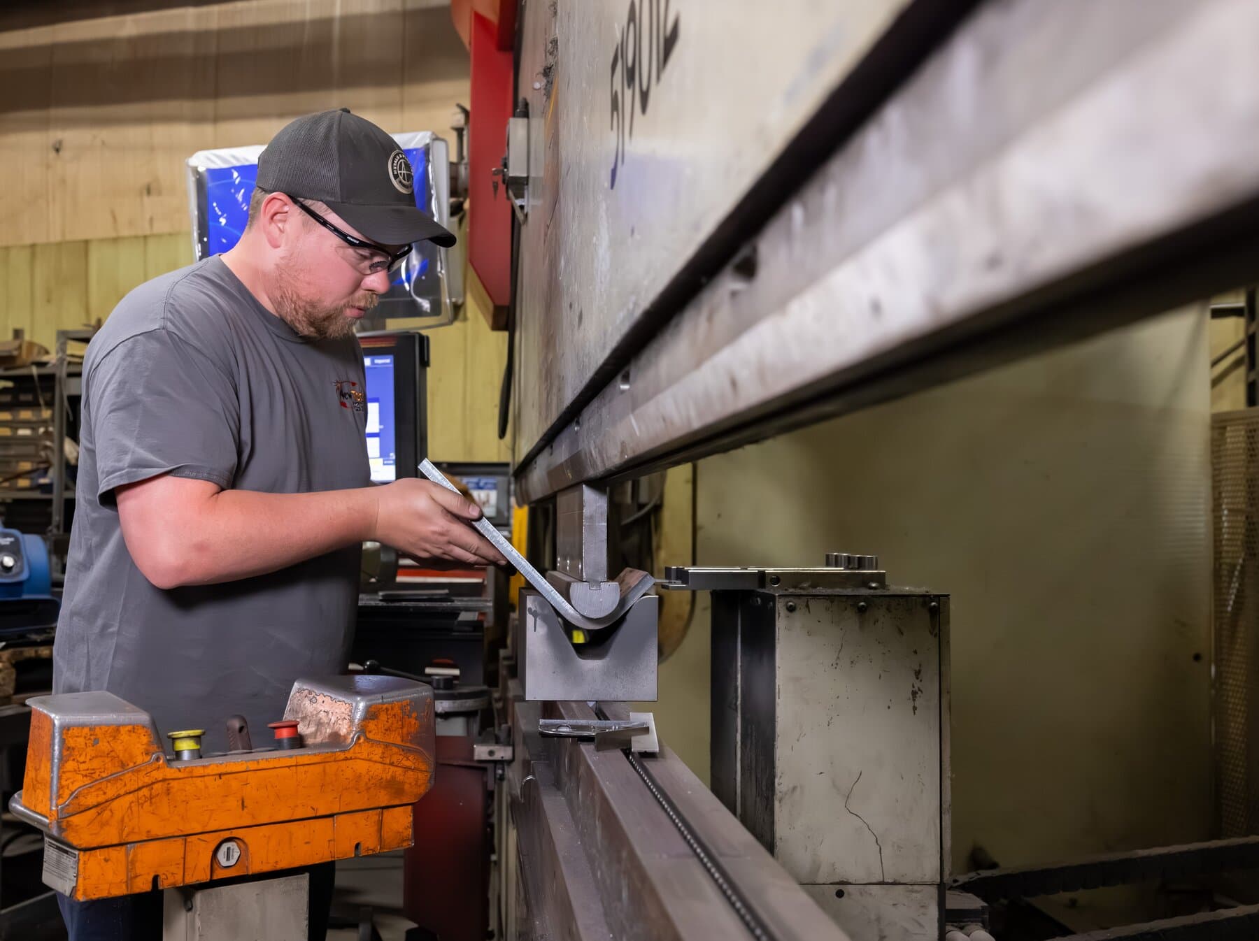 Operator running a long part on the 12-foot hydraulic Accurpress press brake at New Tech Metals