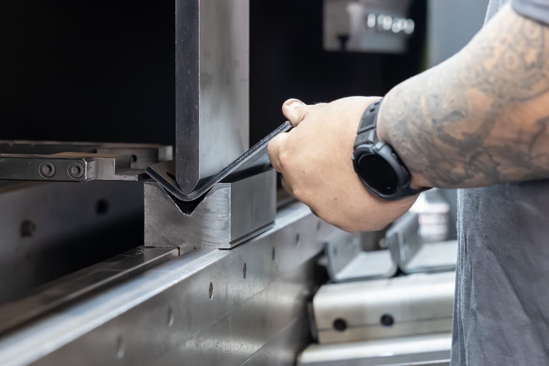 Close-up of a precision sheet-metal bend forming in the Safan press brake at New Tech Metals