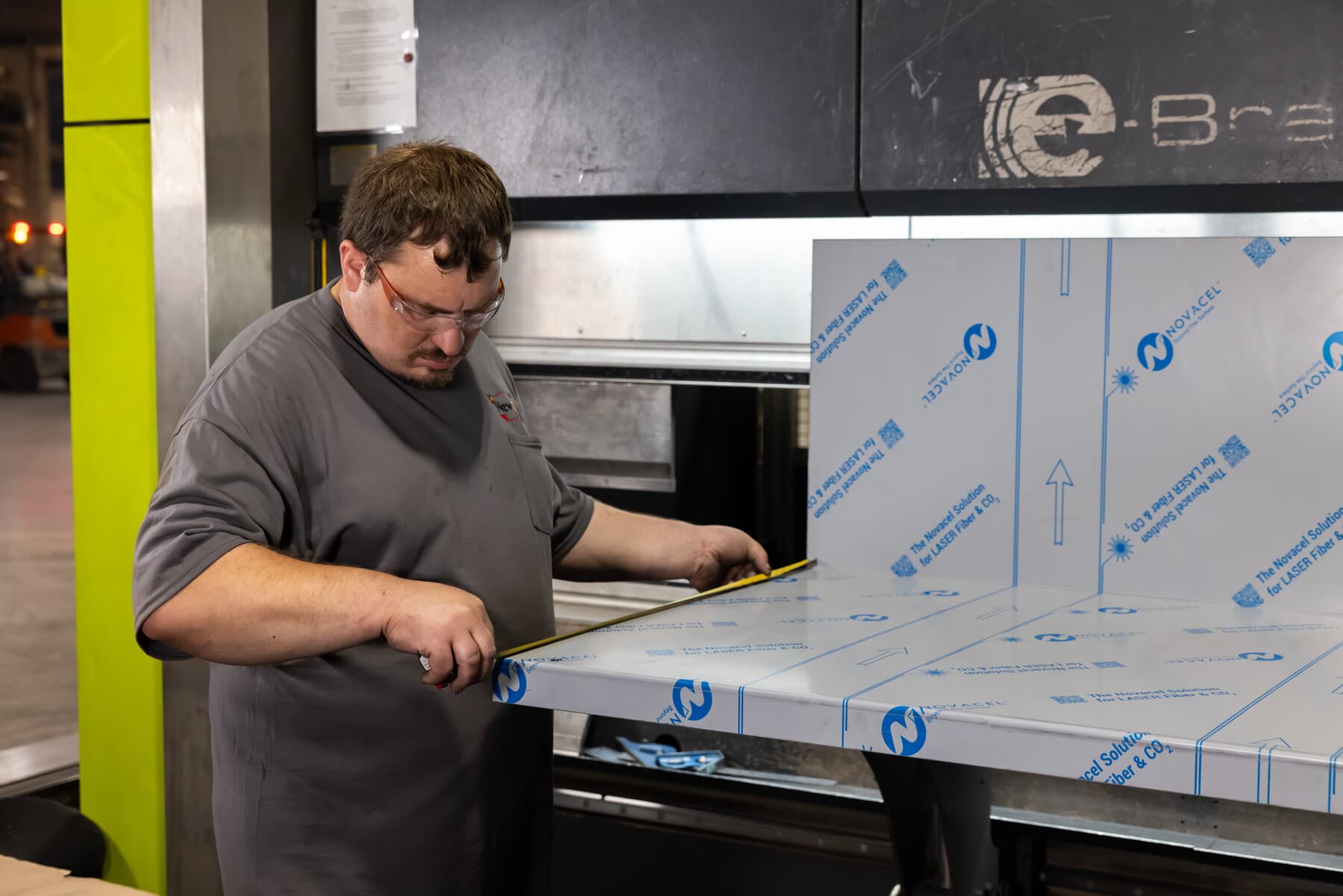 Operator measuring a formed stainless panel at the Safan press brake