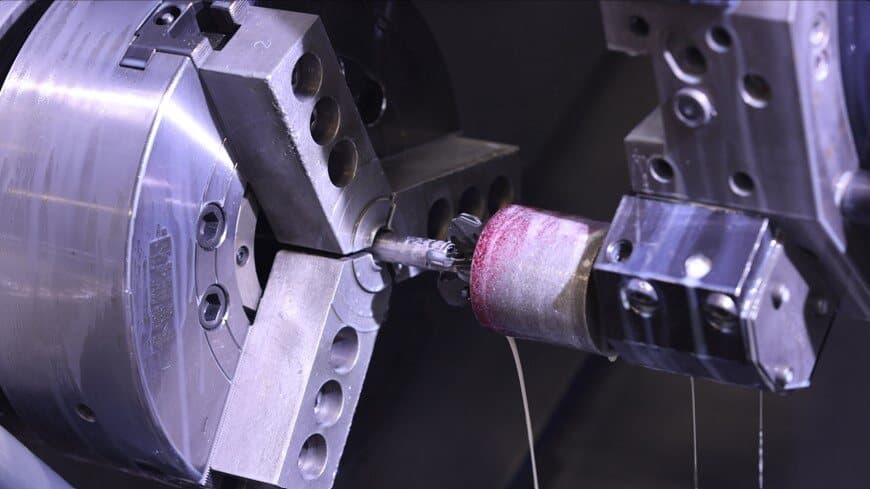 Bar pulling between a CNC lathe chuck and sub-spindle at New Tech Metals