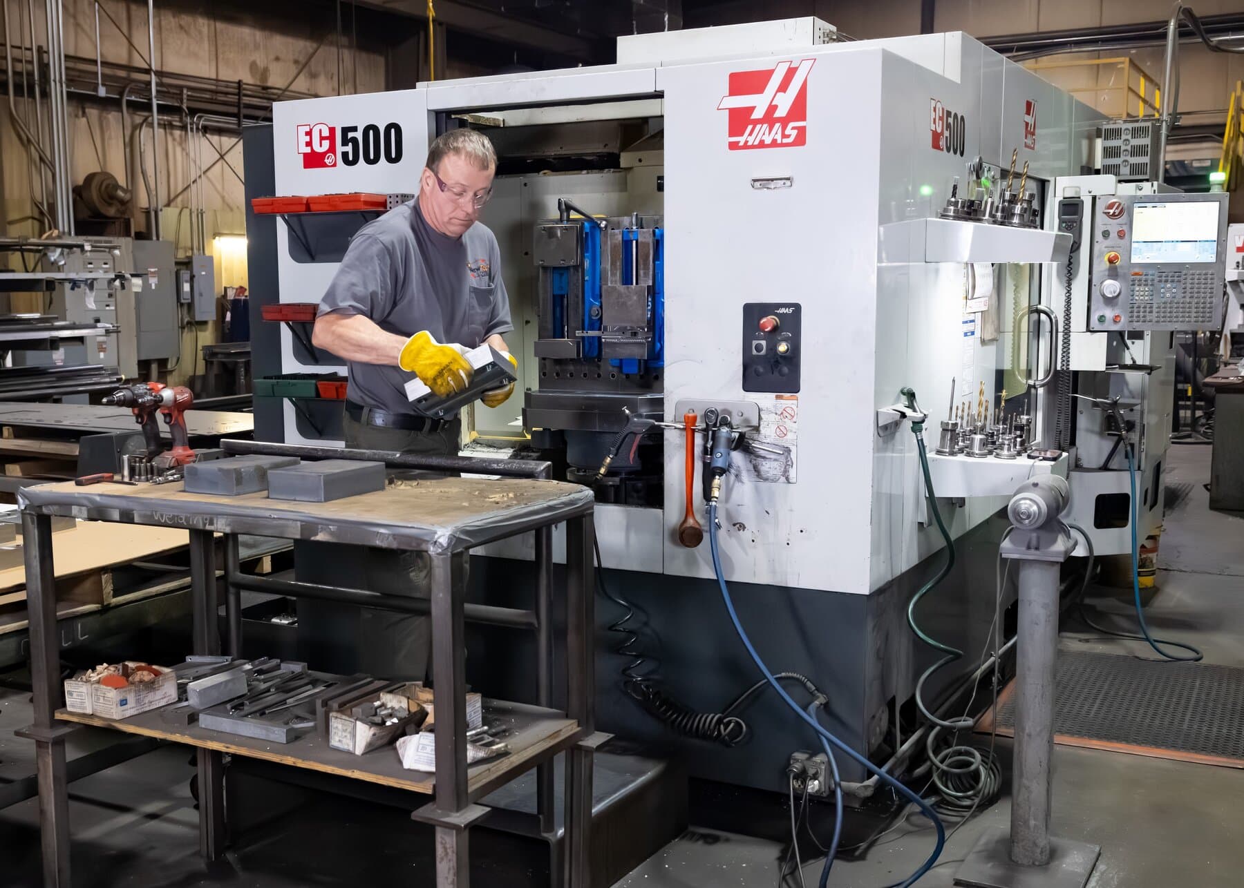 Machinist loading a part into the Haas EC-500 horizontal machining center