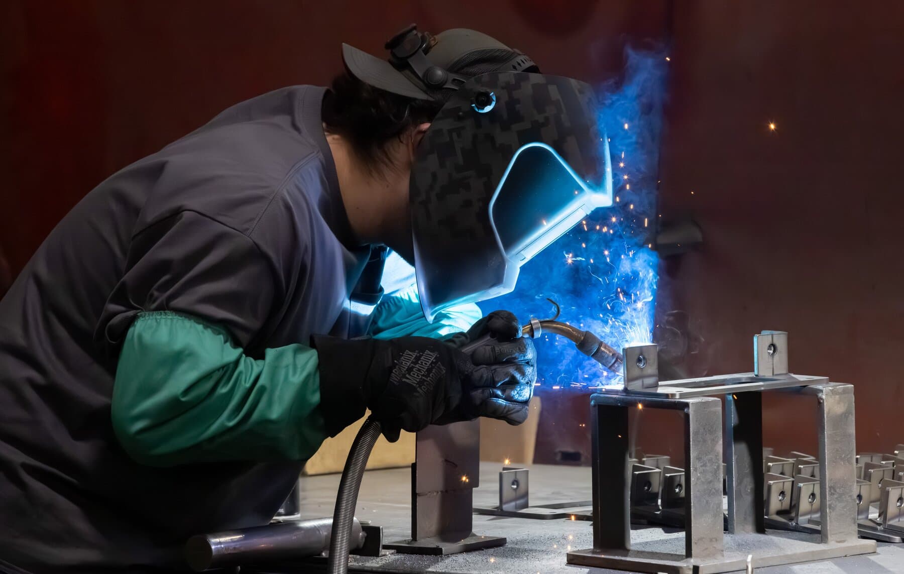 New Tech Metals welder fabricating a component assembly with a blue arc