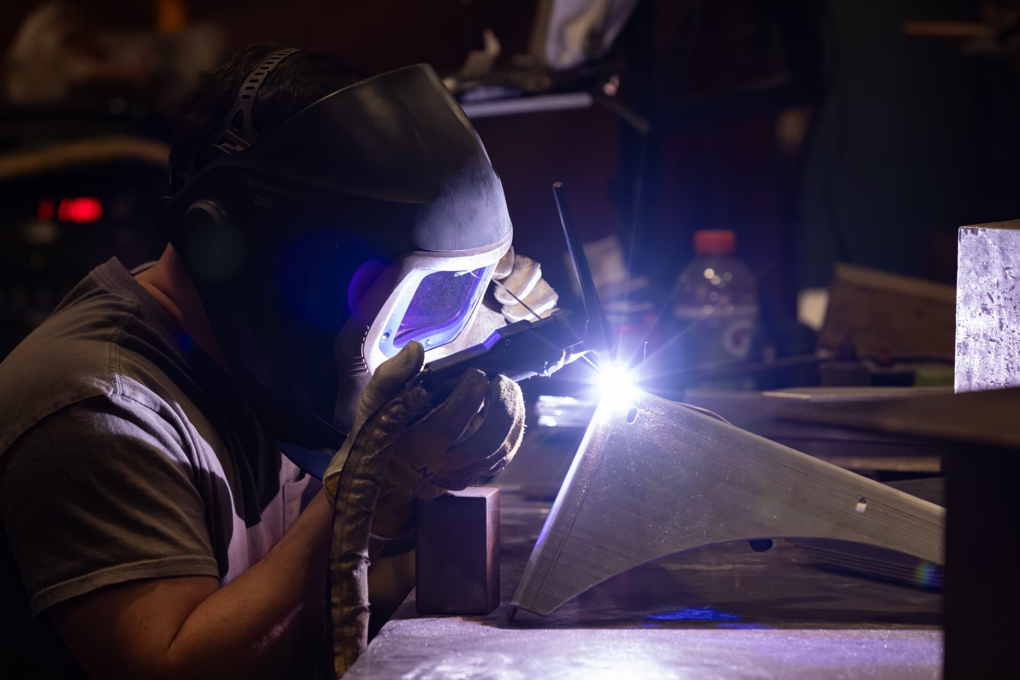 New Tech Metals welder TIG welding a precision stainless steel part with a bright arc